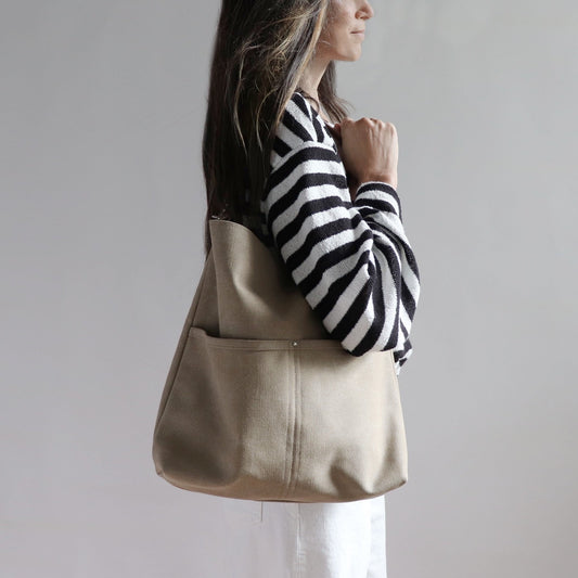 Hobo Style Shoulder Bag in beige canvas shown on model in casual summer outfit