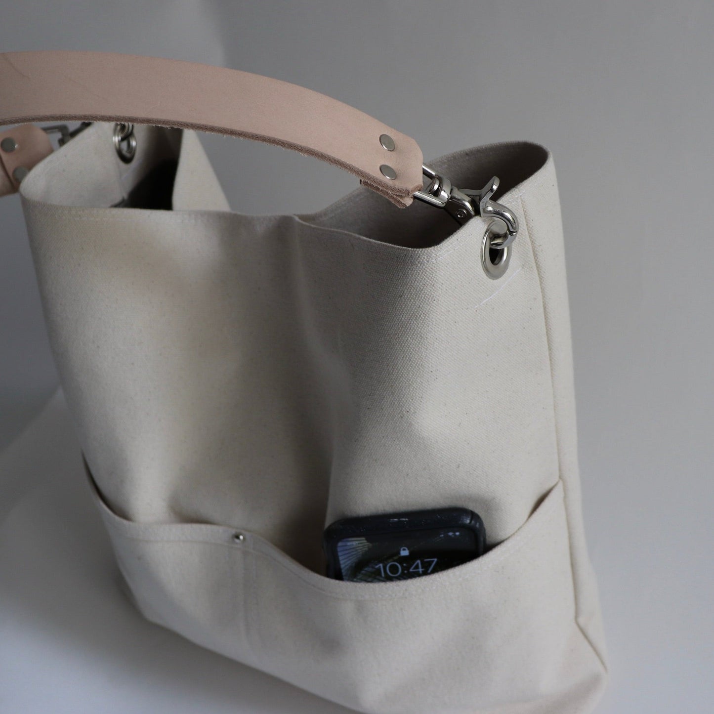 close up view of natural canvas bucket bag with leather strap